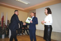 Dyrektor szkoły wraz z wychowawczynią wręczają świadectwo ukończenia szkoły uczniowi