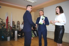 Dyrektor szkoły wraz z wychowawczynią wręczają świadectwo ukończenia szkoły uczniowi