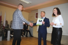 Dyrektor szkoły wraz z wychowawczynią wręczają świadectwo ukończenia szkoły uczniowi