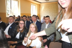 Uczniowie siedzą, w tle ściana