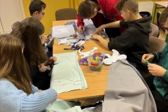 Uczniowie wycinają form maskotek z materiału