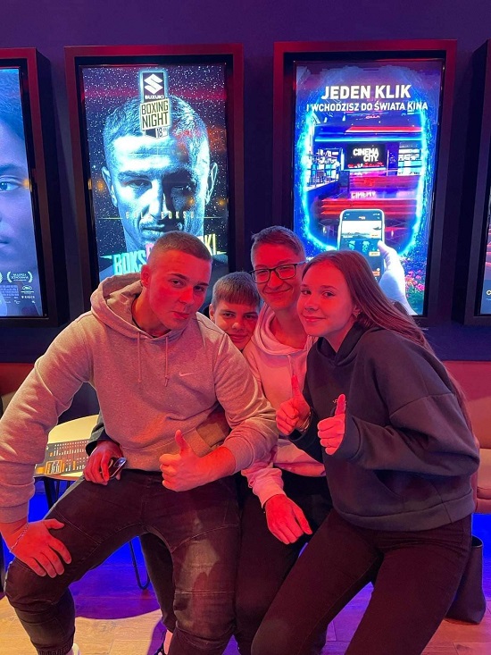 Uczniowie siedzą, w tle plakat z napisem "Jeden klik i wchodzisz do świata kina".